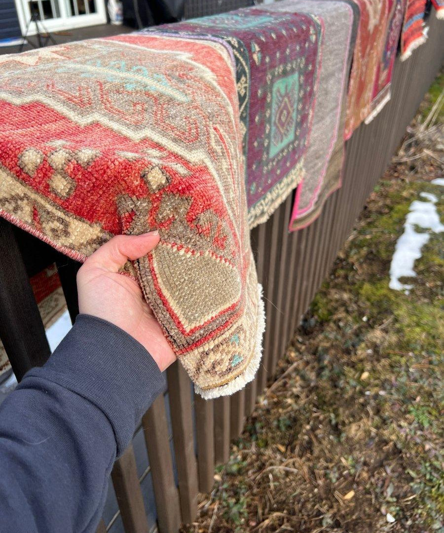 Turkish mini rug close-up corner: red and cream geometric pattern with short fringe.