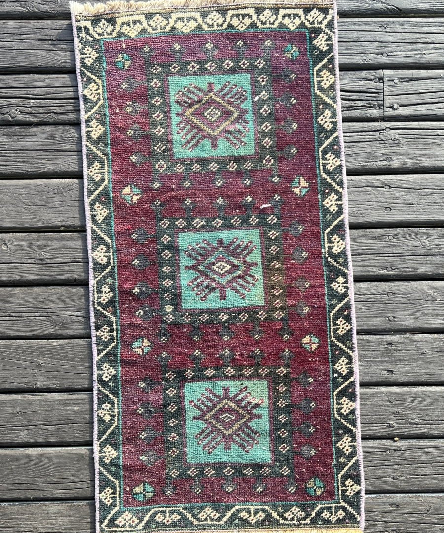 Burgundy Turkish mini rug with cream border and teal geometric medallions