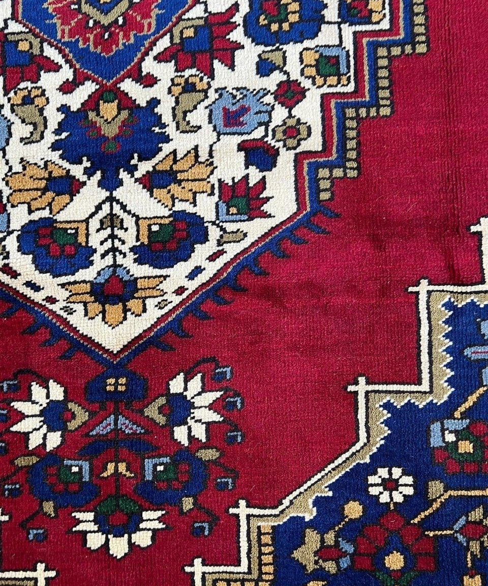 Turkish Taspinar rug detail: red field with blue, white, and gold geometric motifs