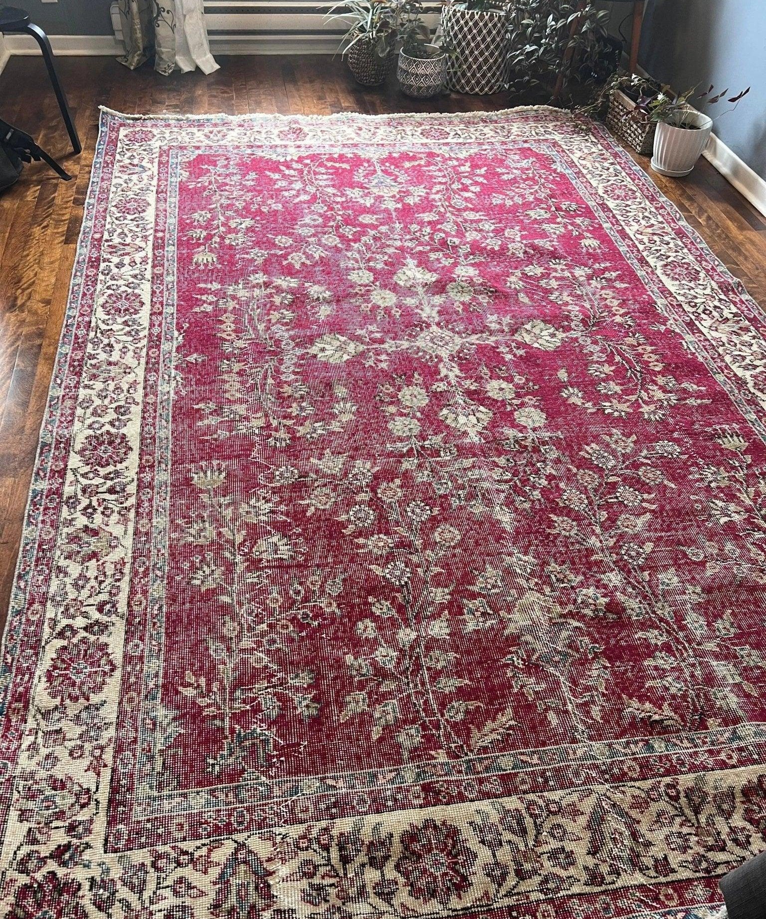 Large red Turkish-style rug with cream floral details and wide patterned border