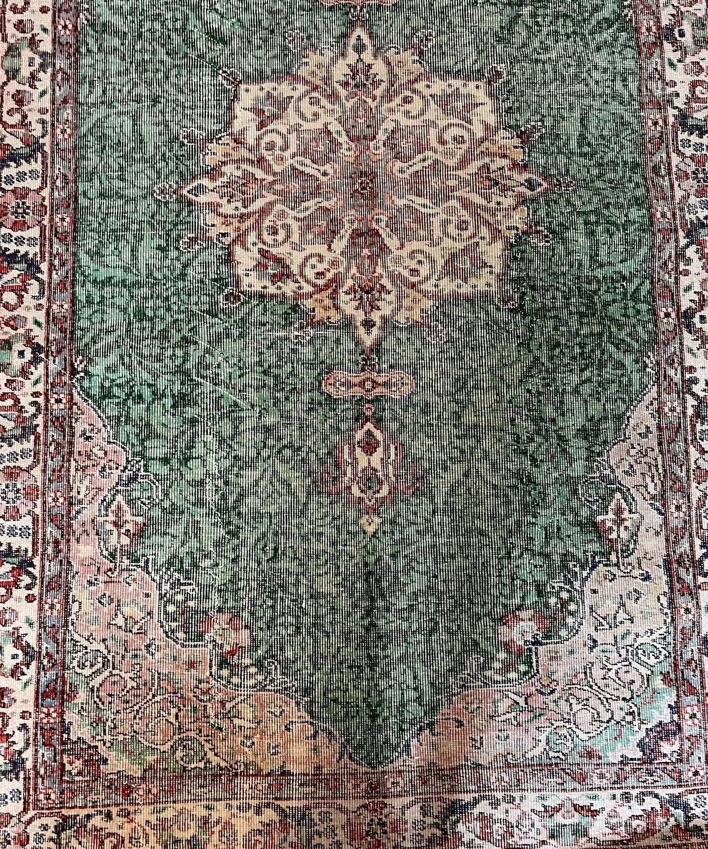 Green vintage rug with central medallion and ornate patterned border