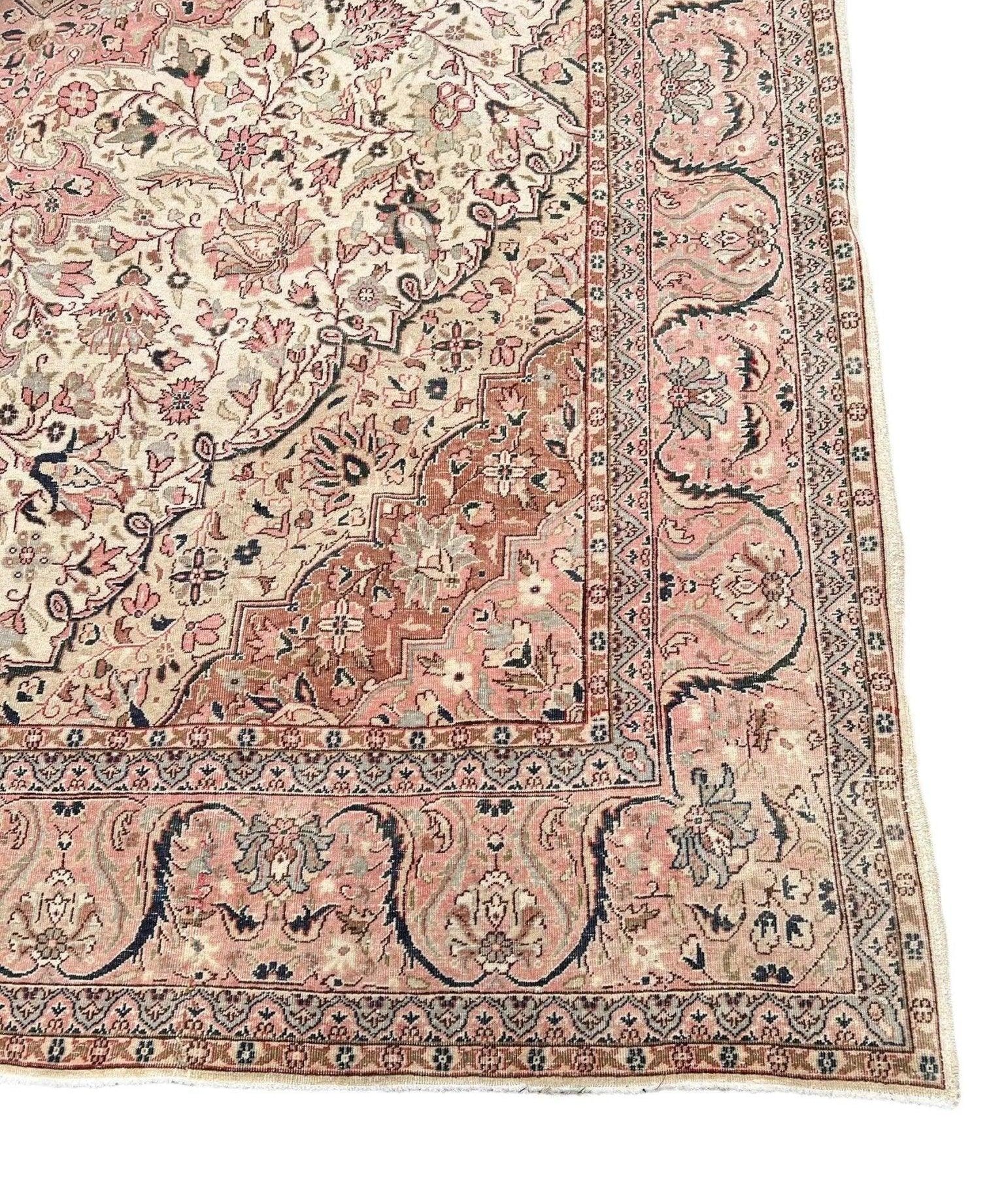 Vintage rug corner with cream field, pink medallions, and detailed border stripe
