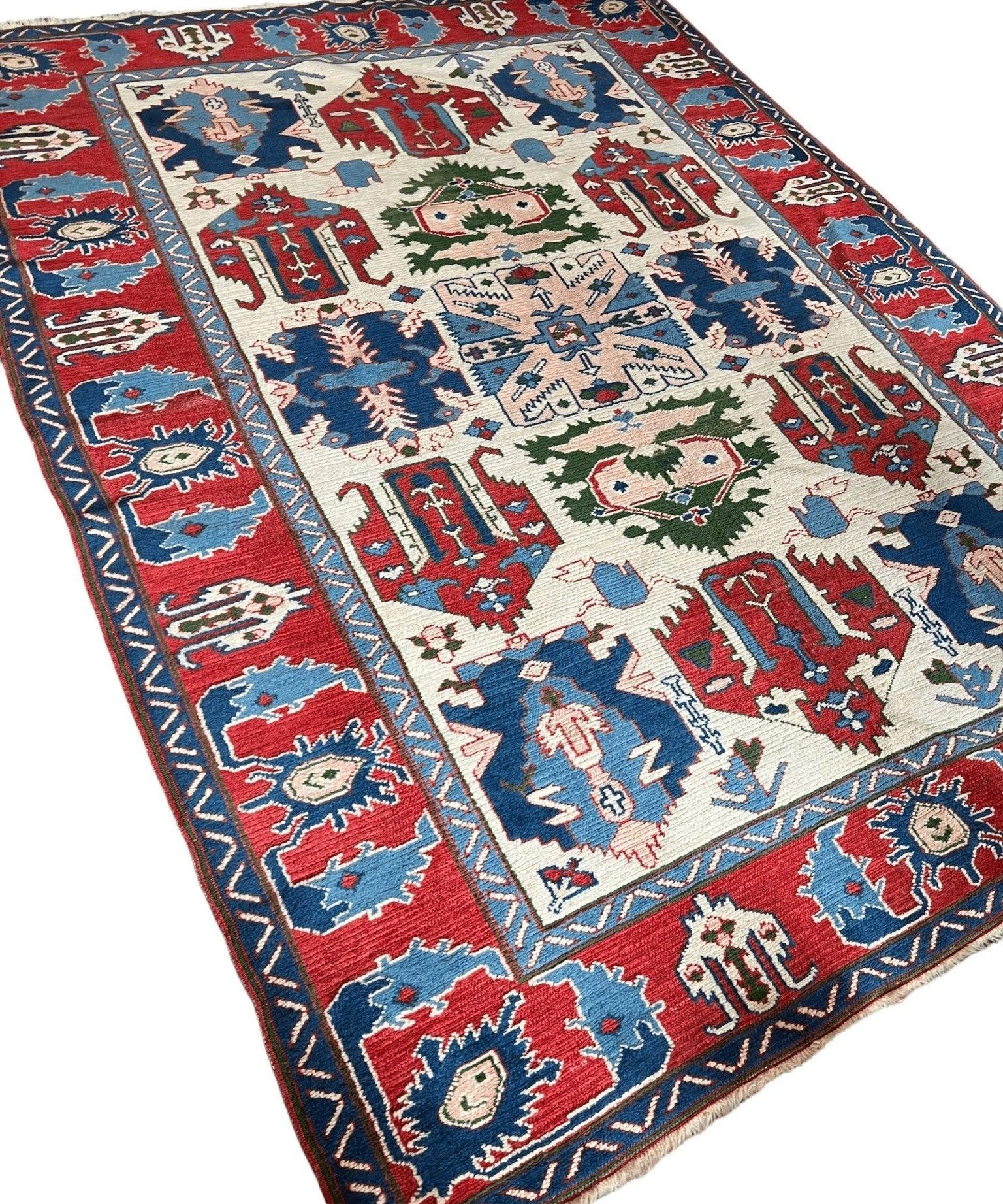 Wool rug with red, blue, and cream medallions and vines, angled view.