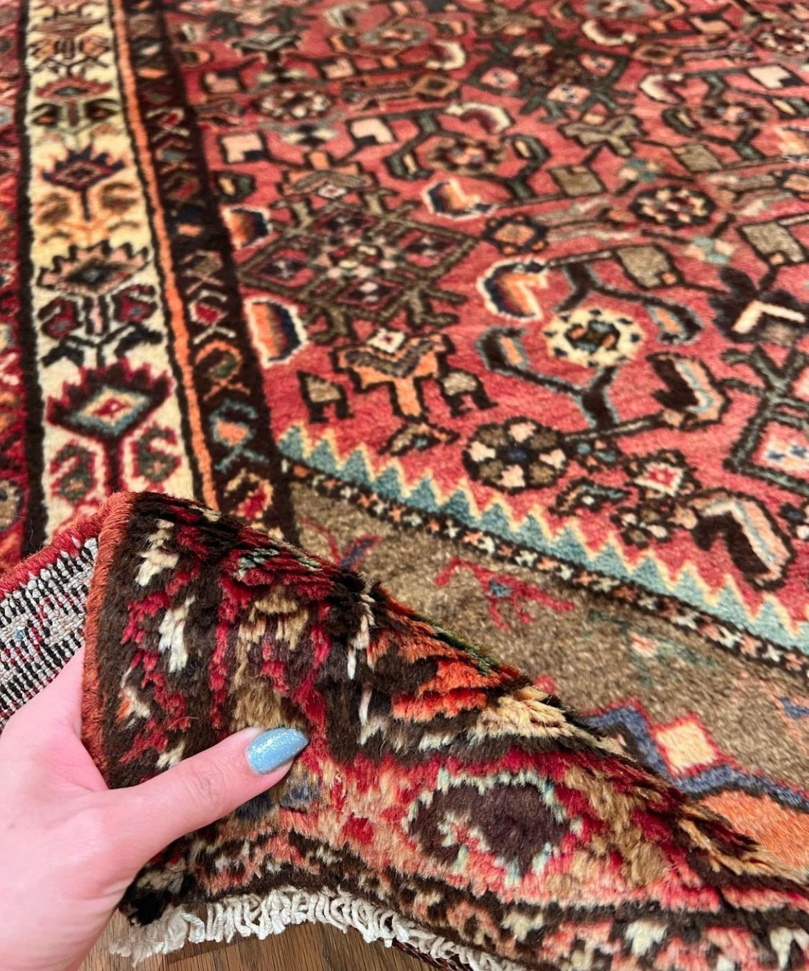 Close-up of vintage runner rug fringe in red, black, and beige with tribal pattern