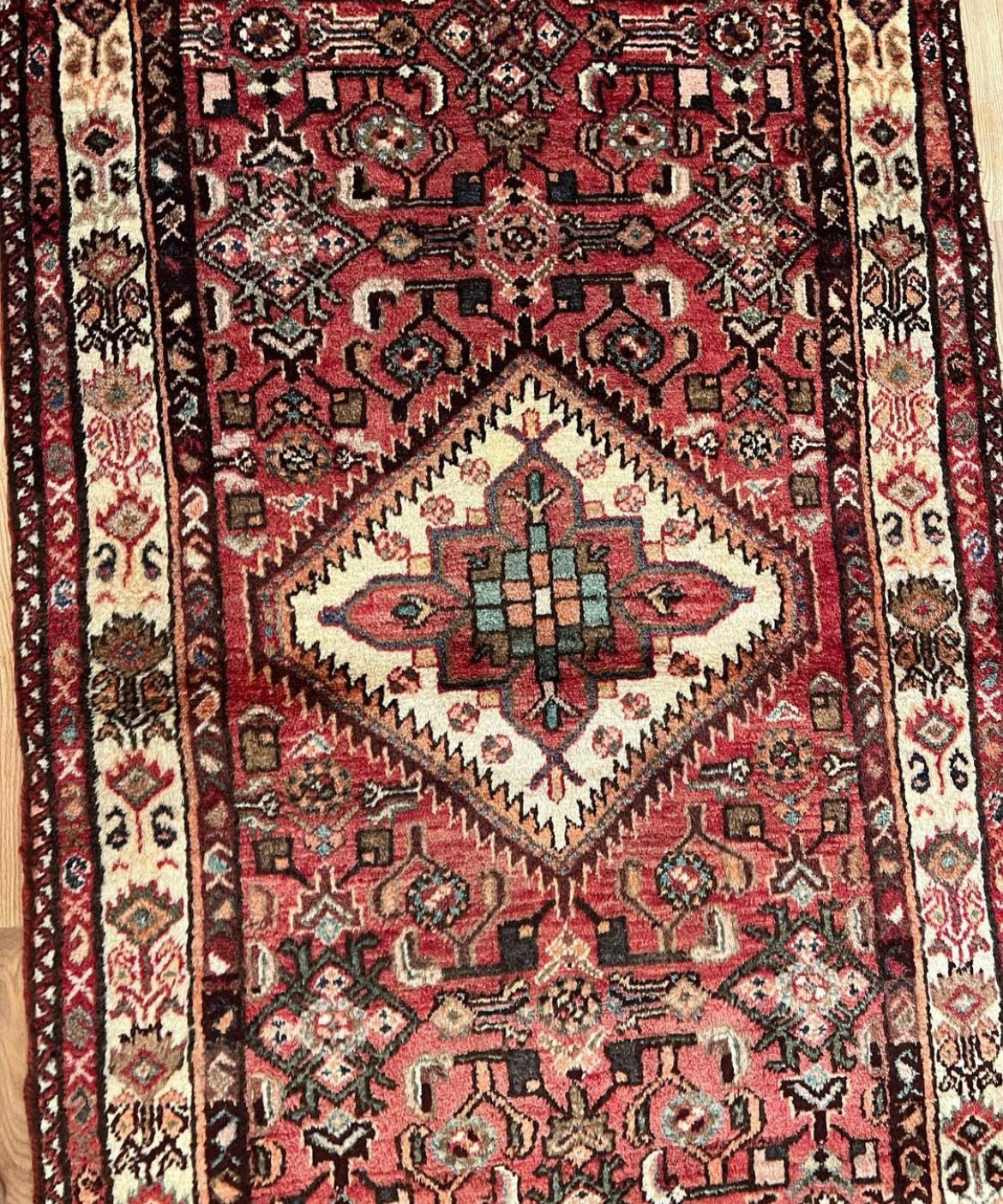 Vintage runner rug section with red field, diamond medallion, and ornate motifs