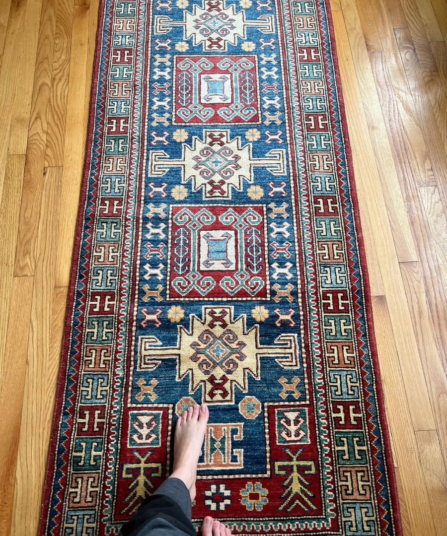 Vintage Kazak runner rug with blue field, red border, geometric medallions