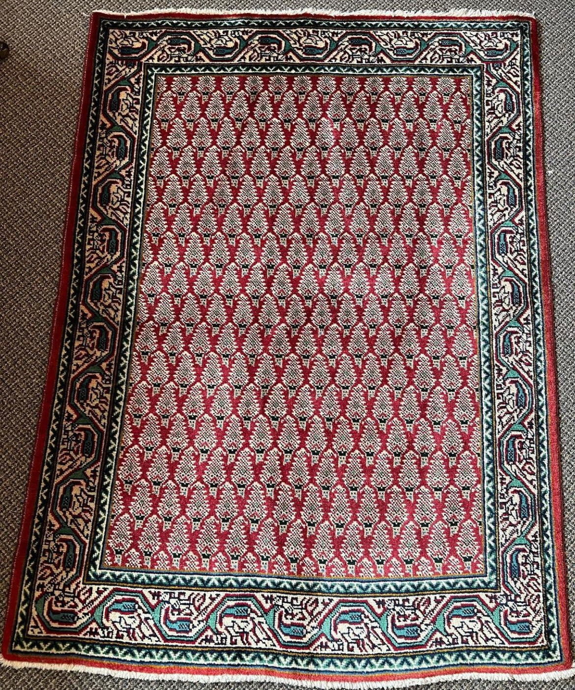 Tabriz rug, red patterned center with ornate navy border and teal accents