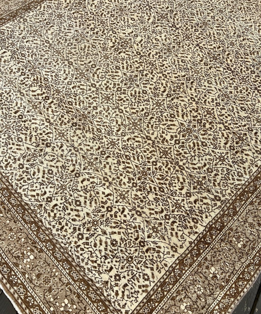 Vintage Turkish rug close-up with dense ivory and dark-brown geometric motifs and corner lines