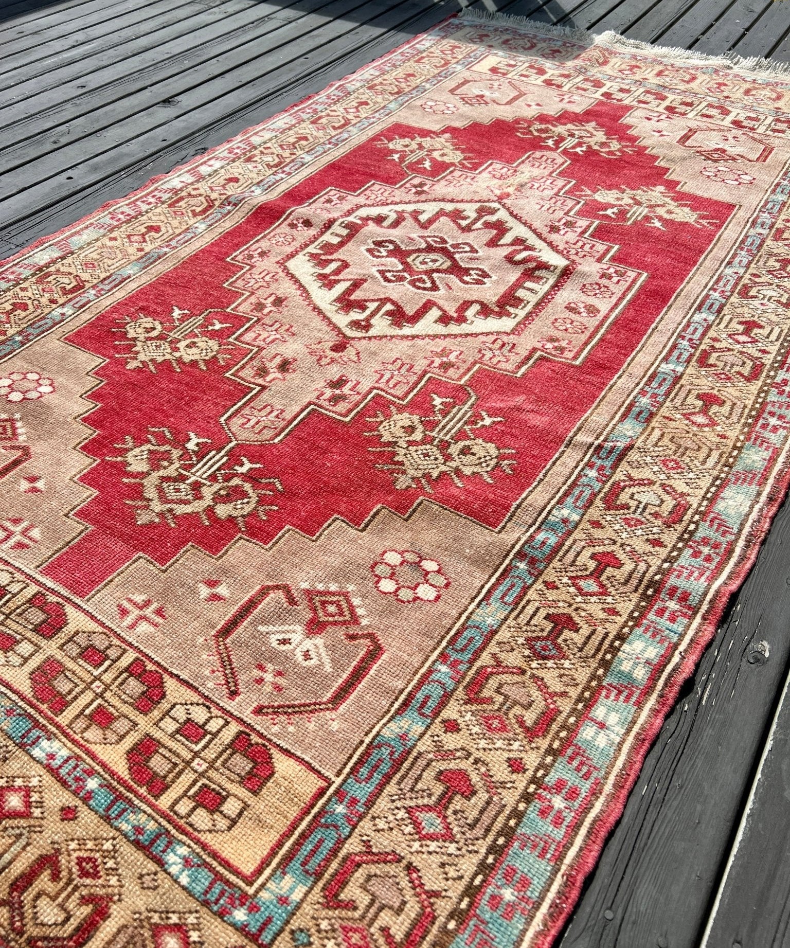 Red Turkish rug with cream accents and repeating geometric border design